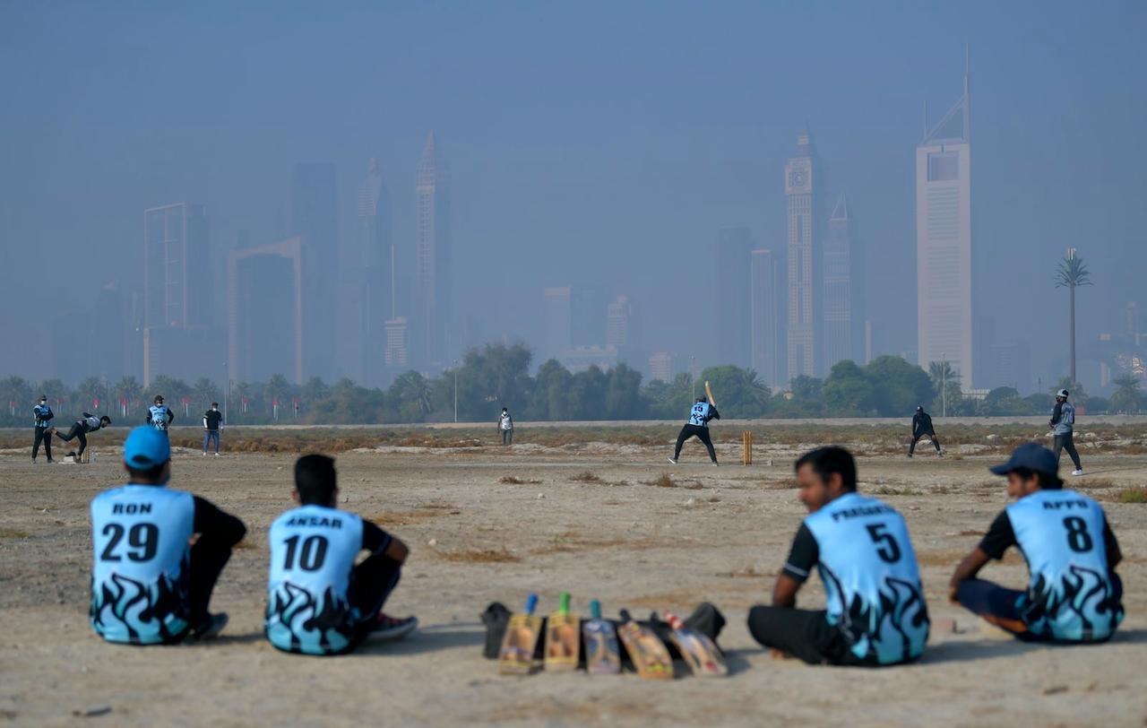Workers play cricket on their day off work on December 4, 2020, in Dubai. (AFP Photo)