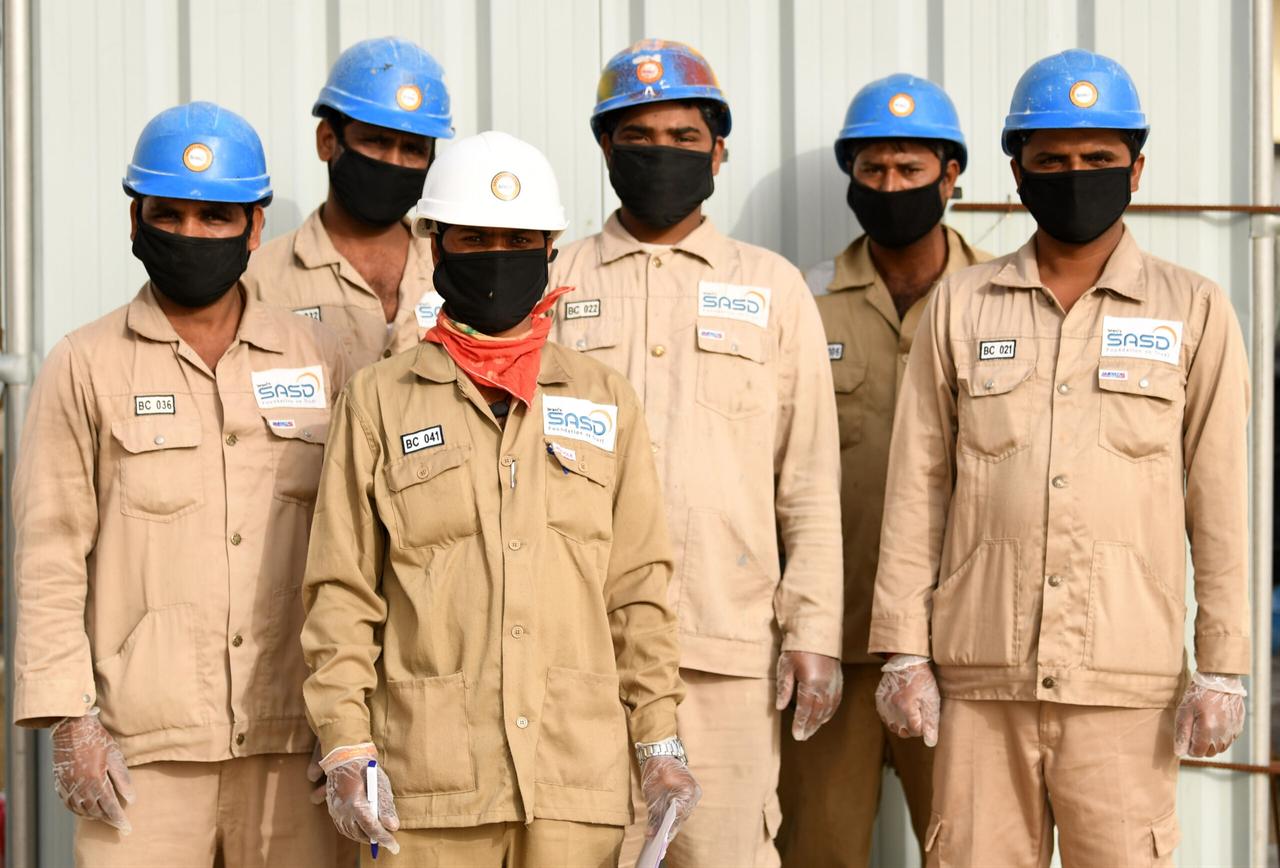 Men working for a public services company in the United Arab Emirates pose for a photo wearing protective gear, masks, and gloves in Dubai, April 2, 2020. (AFP Photo)