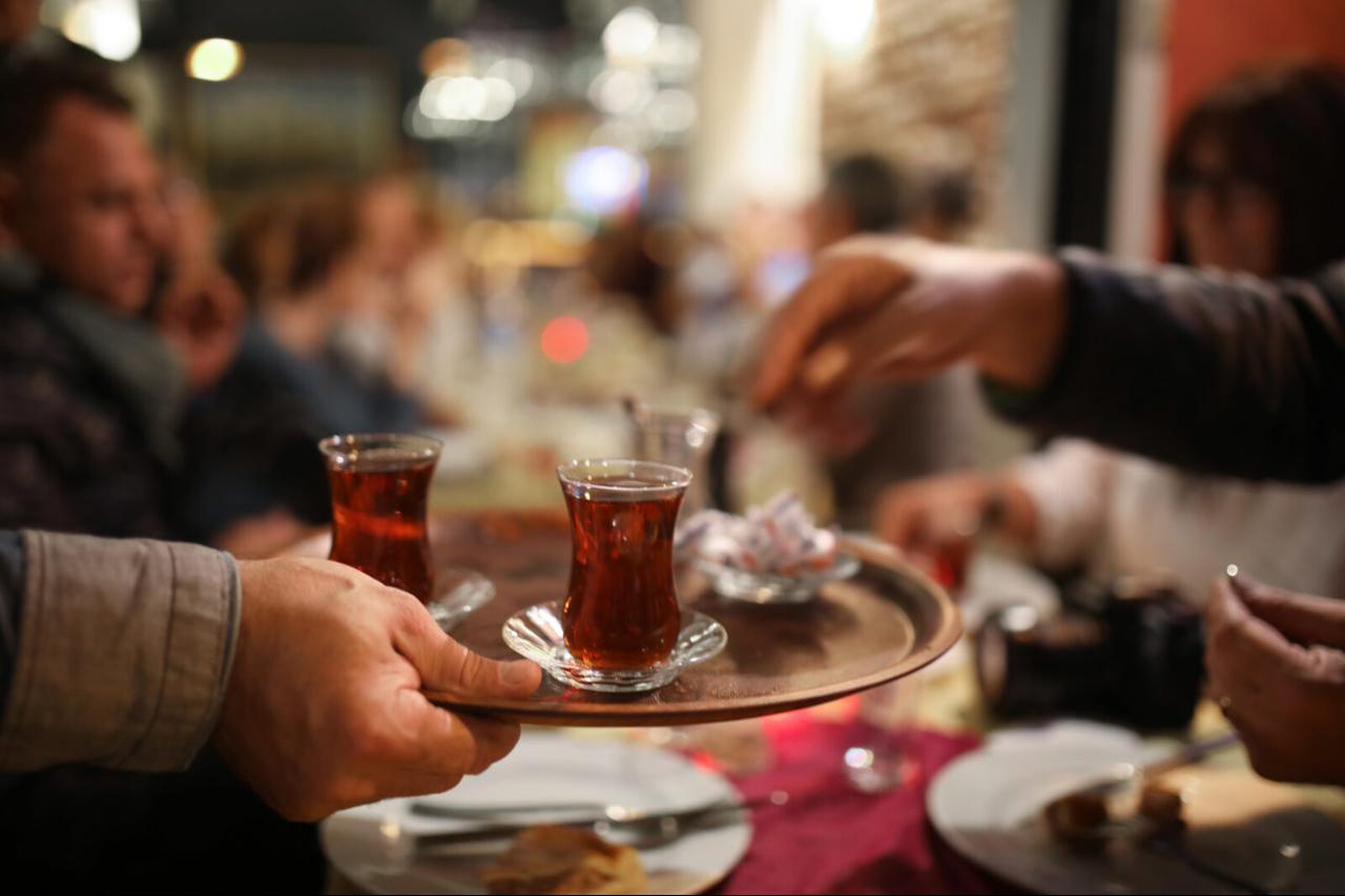 A man serving Turkish tea, a symbol of hospitality and tradition, in Türkiye. (Adobe Stock Photo)
