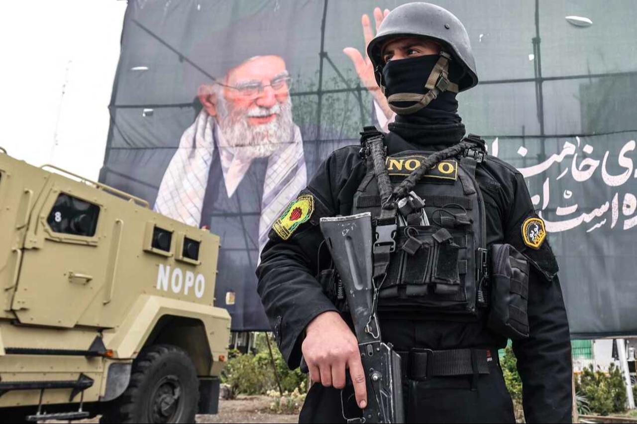 A member of the Iranian security forces stands guard next to a banner honouring Iran's slain supreme leader Ali Khamenei in Tehran, Iran, March 31, 2026. (AFP Photo)