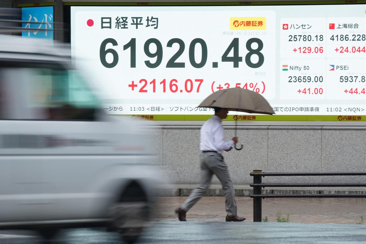 A man walks past an electronic quotation boards displaying the Nikkei Stock Average on the Tokyo Stock Exchange along a street in Tokyo, Japan, May 21, 2026. (AFP Photo)