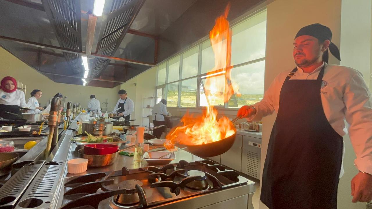 A chef from Türkiye Gastronomy Federation flambés food in a professional training kitchen. (AA Photo)
