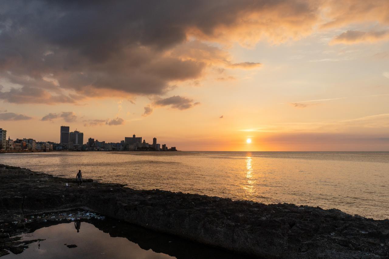 People swim and fish along the seawall as the sun sets over the Malecon, where daily life continues against the backdrop of Havana’s coastline in Havana, Cuba, May 9, 2026. (AA Photo)