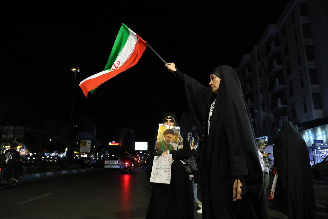 Women hold Iran's national flag and photo of country's supreme leader Mojtaba Khamenei during an anti-US and Israel protest at the Hafte Tir Square in Tehran, Iran, May 17, 2026. (AFP Photo)