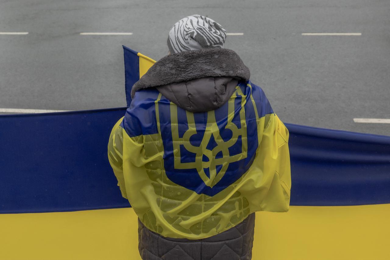 A woman waits along a road to greet released Ukrainian prisoners of war (POWs) following a prisoner exchange, in the Chernihiv region on May 15, 2026. (AFP Photo)