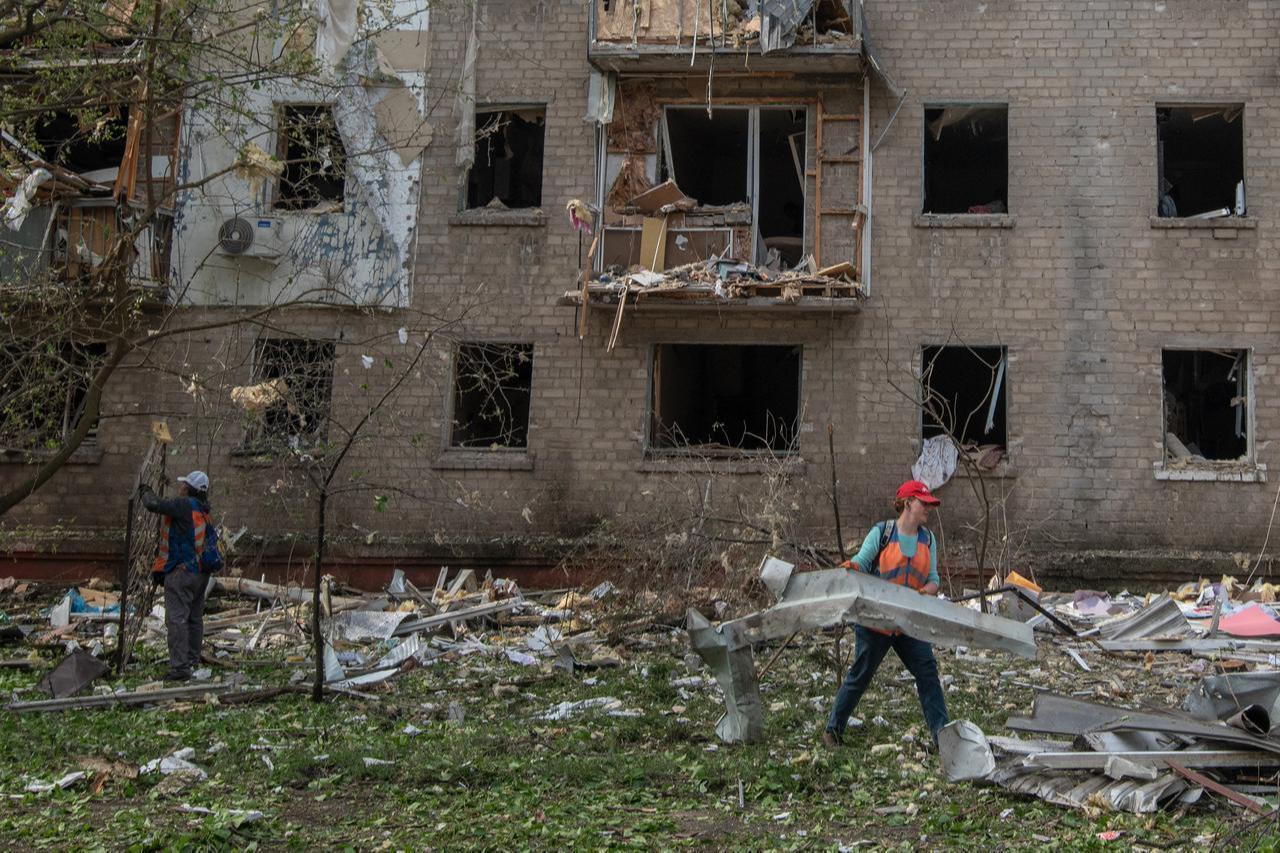 Communal workers clean debris in the courtyard of a damaged residential building following an air attack in Dnipro on May 18, 2026. (AFP Photo)