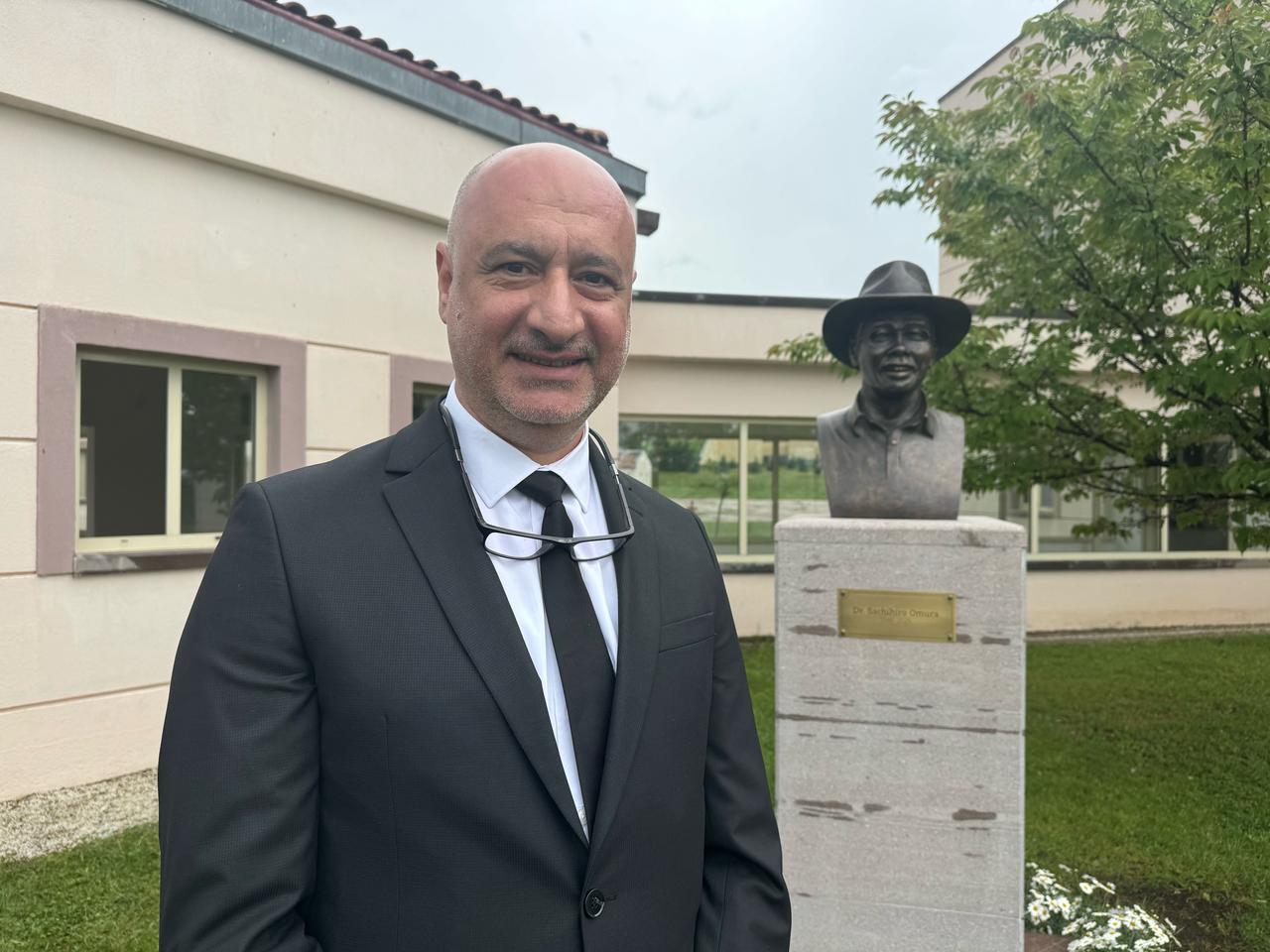 Sculptor Hakan Ersiz poses in front of the bronze bust of Japanese archaeologist Dr. Sachihiro Omura at the Japanese Institute of Anatolian Archaeology in Kaman, Kirsehir, Türkiye, May 22, 2026. (AA Photo)