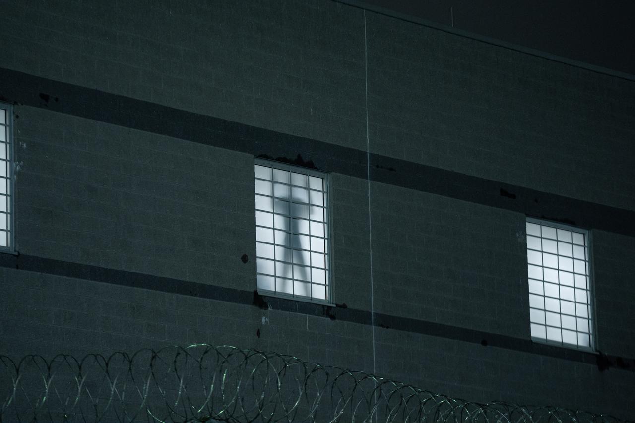 Detainees signal to protesters behind  window at Delaney Hall Immigration Detention Center, May 24, 2026. (AA Photo)
