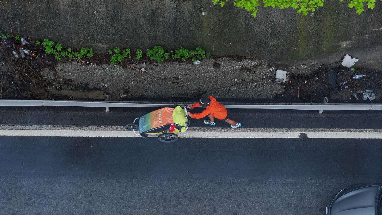 An aerial view shows Chinese traveler Xiong Xianjun pushing his handcart along a road in Duzce, Türkiye, May 26, 2026. (AA Photo)