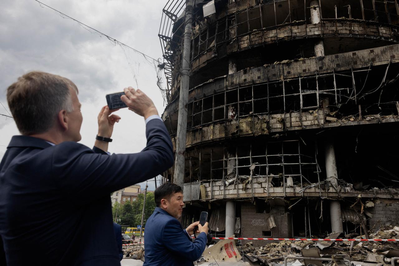 Members of diplomatic missions to Ukraine take pictures as they visit a heavily damaged shopping center following Russian strikes in Kyiv on May 25, 2026. (AFP Photo)