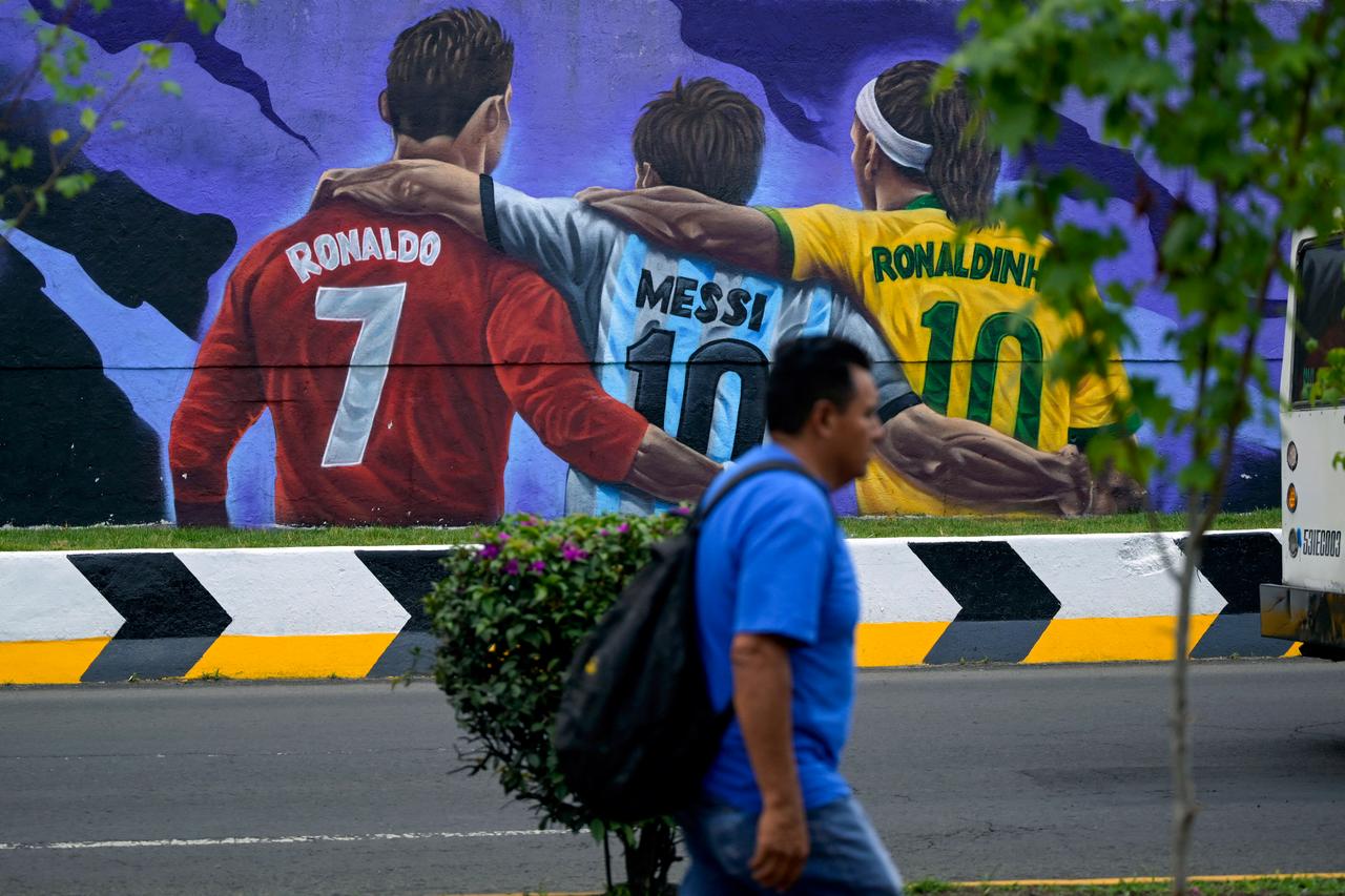 A man walks past a hand-painted mural featuring 2026 World Cup motifs in Mexico City on May 25, 2026, by the artists Josa Cruz Pacheco, Andreee Orozco, Francisco Thomas Arriaga, Vivian Velazquez Ventura, and Christian Zuniga Lazcano.(AFP Photo)