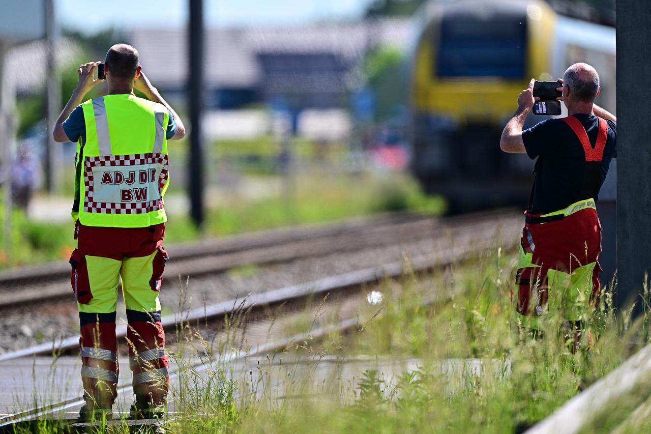 Emergency services take images with their smartphones at the site of an accident after a train crashed into a school bus, at the railway crossing Vierhuizen in Buggenhout on May 26, 2026. (AFP Photo)
