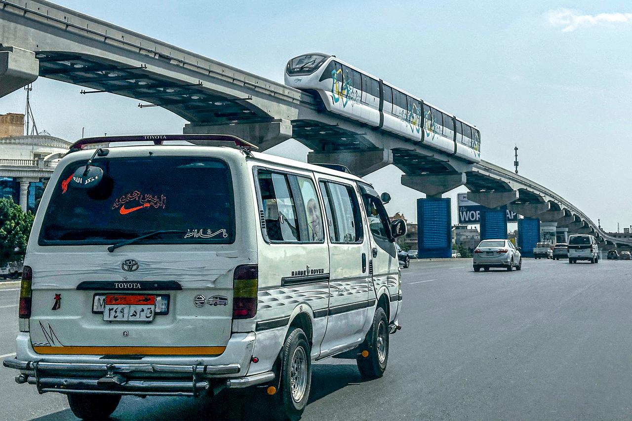 Minibus moves along main road underneath Cairo Monorail track, May 22, 2026. (AFP Photo)