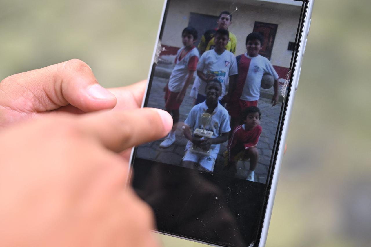 Jeremy Cedeno, childhood friend of Moises Caicedo, showing a picture of him as a child holding a cup in downtown Santo Domingo, Ecuador, on May 8, 2026. (AFP Photo)