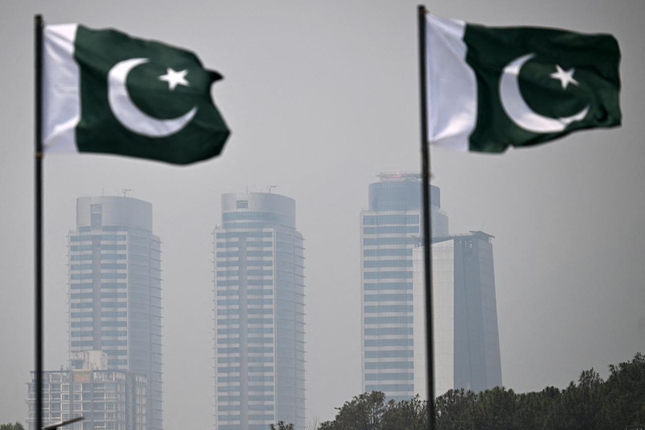 Pakistani national flags flutter as buildings are seen in the background amid smoggy conditions in Islamabad on May 10, 2026. (AFP Photo)