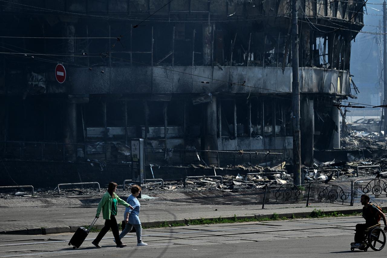 People pass by a burned down shopping centre following Russian strikes in Kyiv on May 24, 2026, amid the Russian invasion of Ukraine. (AFP Photo)