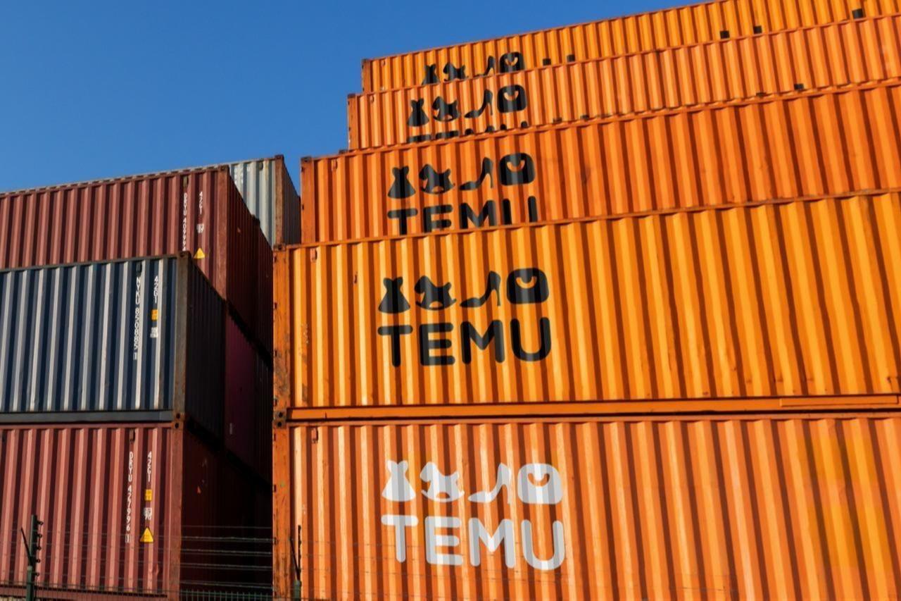 Shipping containers bearing the logo of Chinese e-commerce platform Temu are stacked at a freight yard. (Adobe Stock Photo)