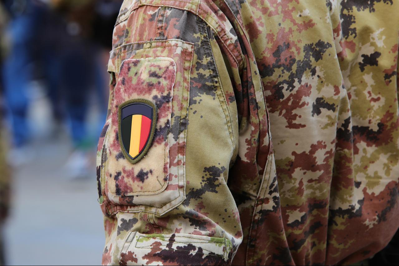 Belgian army personnel in camo, displaying the national flag on the uniform sleeve. (Adobe Stock Photo)
