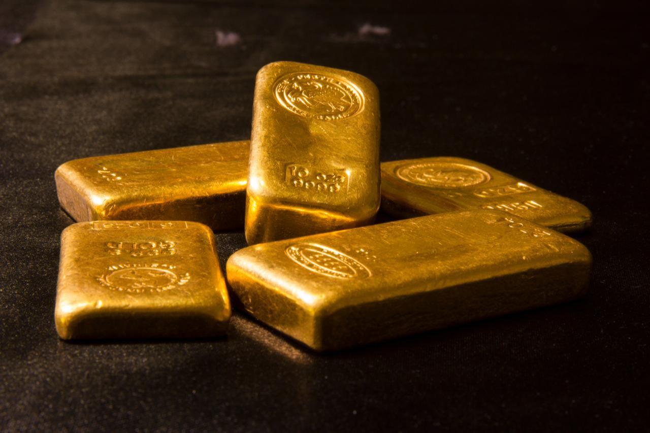 Ten-ounce gold bars on a dark surface. (Adobe Stock Photo)