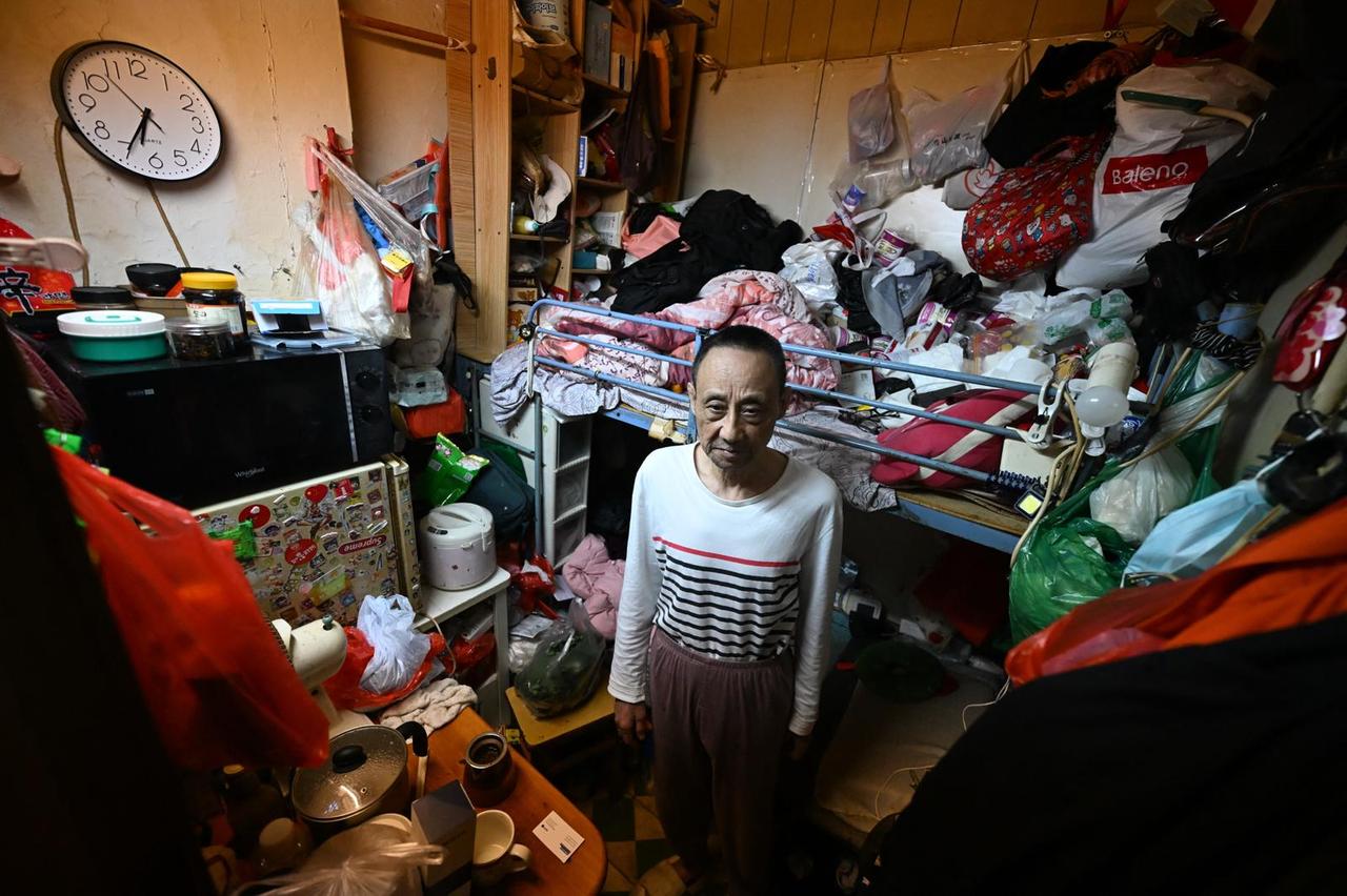 Guan Ci standing in his subdivided housing unit in Kowloon, Hong Kong, April 30, 2026. (AFP Photo)