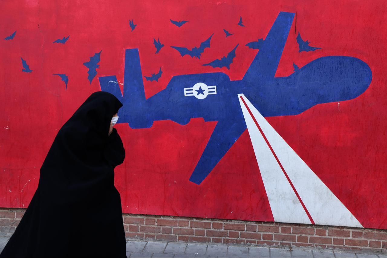 A woman walks past a mural depicting a US drone painted on the outer walls of the former US embassy in Tehran, colloquially-referred to as the "Spy Den,"on Feb. 1, 2026. (AFP Photo)