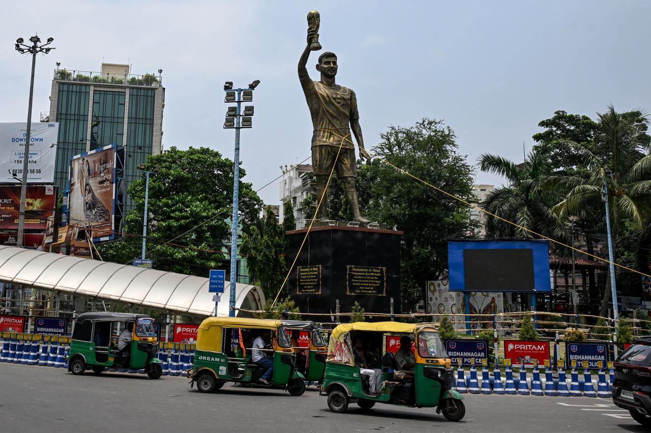 Rickshaws drive past a statue of Argentine football player Lionel Messi that has been tied with rope for stability, in Kolkata, India on May 27, 2026. (AFP Photo)