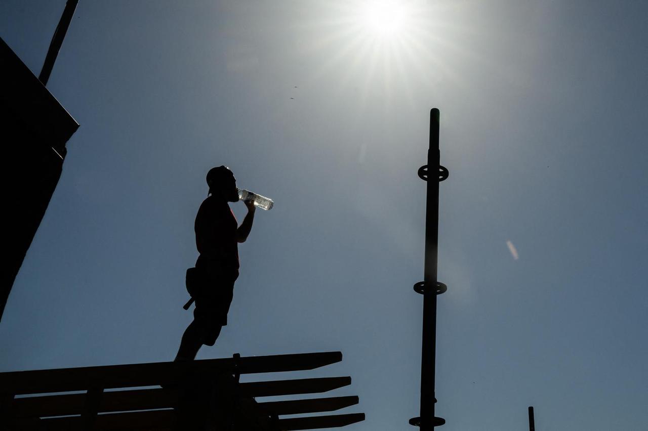 Carpenter drinks water as he works on a rooftop in Nantes, western France, May 27, 2026 (AFP Photo)