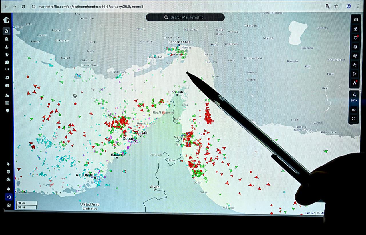 A person points at a page on the MarineTraffic website showing commercial boat traffic along the edge of the Strait of Hormuz near the Iranian coast, in Paris on March 4, 2026. (AFP Photo)