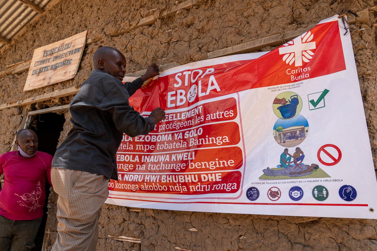 A man hangs an Ebola awareness banner at the Kigonze camp in Bunia, DR Congo, May 28, 2026. (AFP Photo)