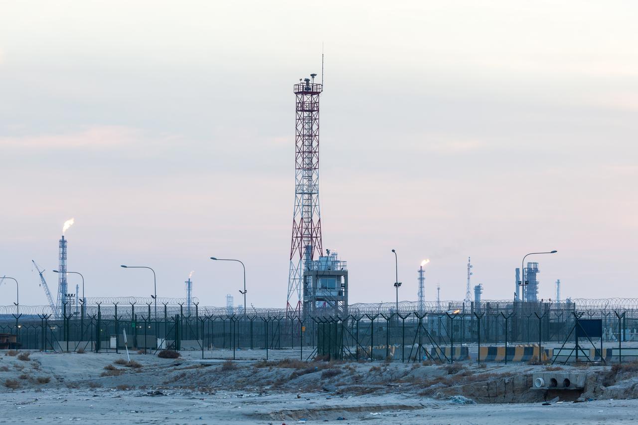 A view of an oil and gas facility with flare stacks, pipelines and processing towers in Kuwait. (Adobe Stock Photo)