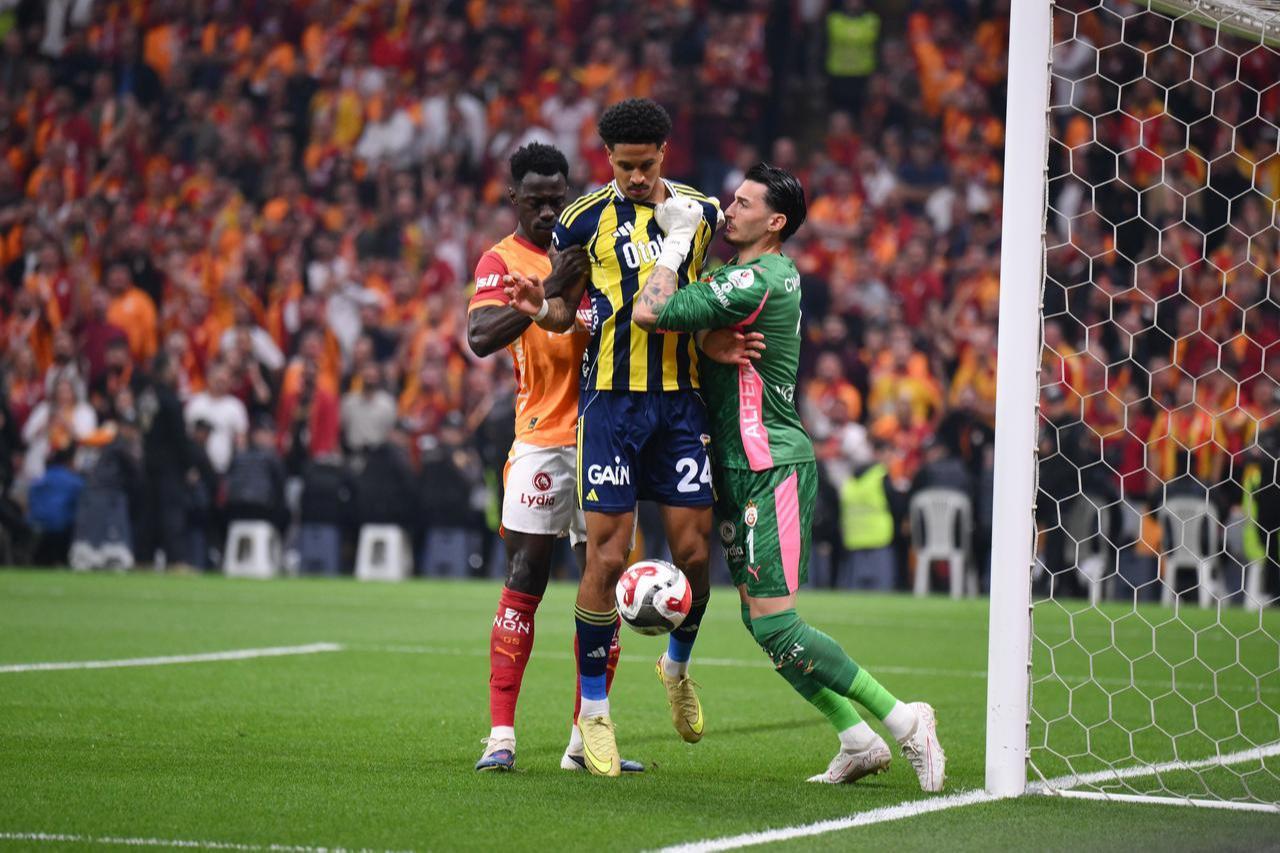 Galatasaray goalkeeper Ugurcan Cakir (R) and Fenerbahce player Jayden Oosterwolde (24) compete for the ball during the Turkish Super Lig week 31 football match between Galatasaray and Fenerbahce at RAMS Park in Istanbul, Türkiye, April 26, 2026. (AA Photo)