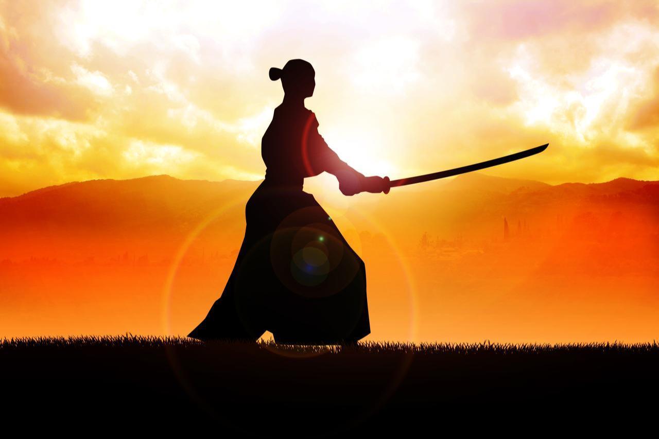 A silhouette of a samurai holding a sword at sunset (Adobe Stock Photo)