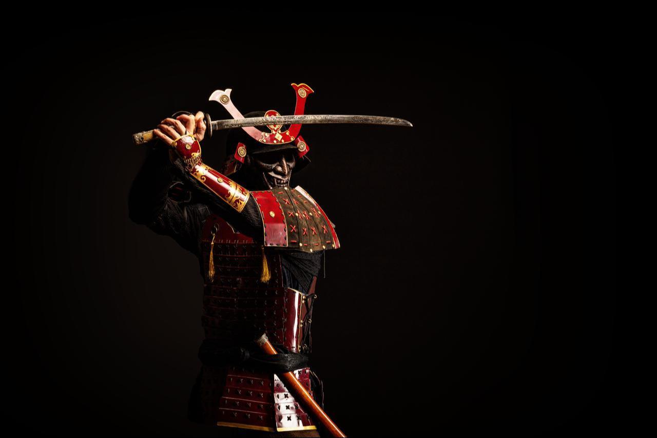 A traditional samurai armor raises a sword against a dark background (Adobe Stock Photo)