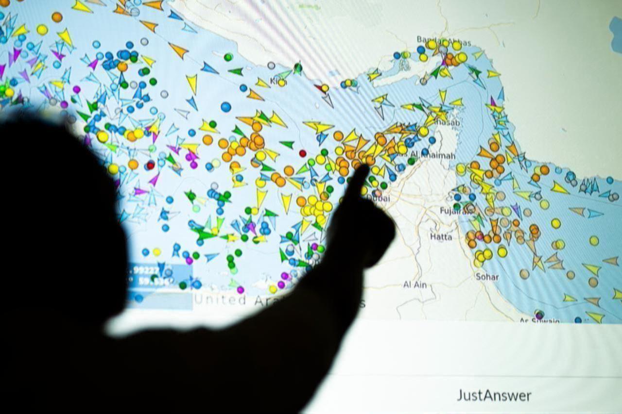 A photo illustration taken in Lefkosia on May 4, 2026, shows a person in front of a large screen displaying vessel movements in the Strait of Hormuz on a ship-tracking website. (AFP Photo)