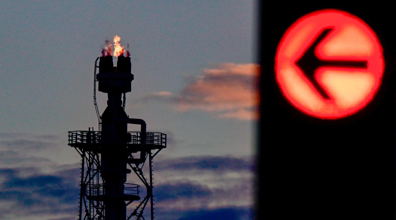 A red traffic light is seen in the foreground next to a tower of the PCK Schwedt refinery in Schwedt, northeastern Germany, at the company's plant on April 30, 2026. (AFP Photo)