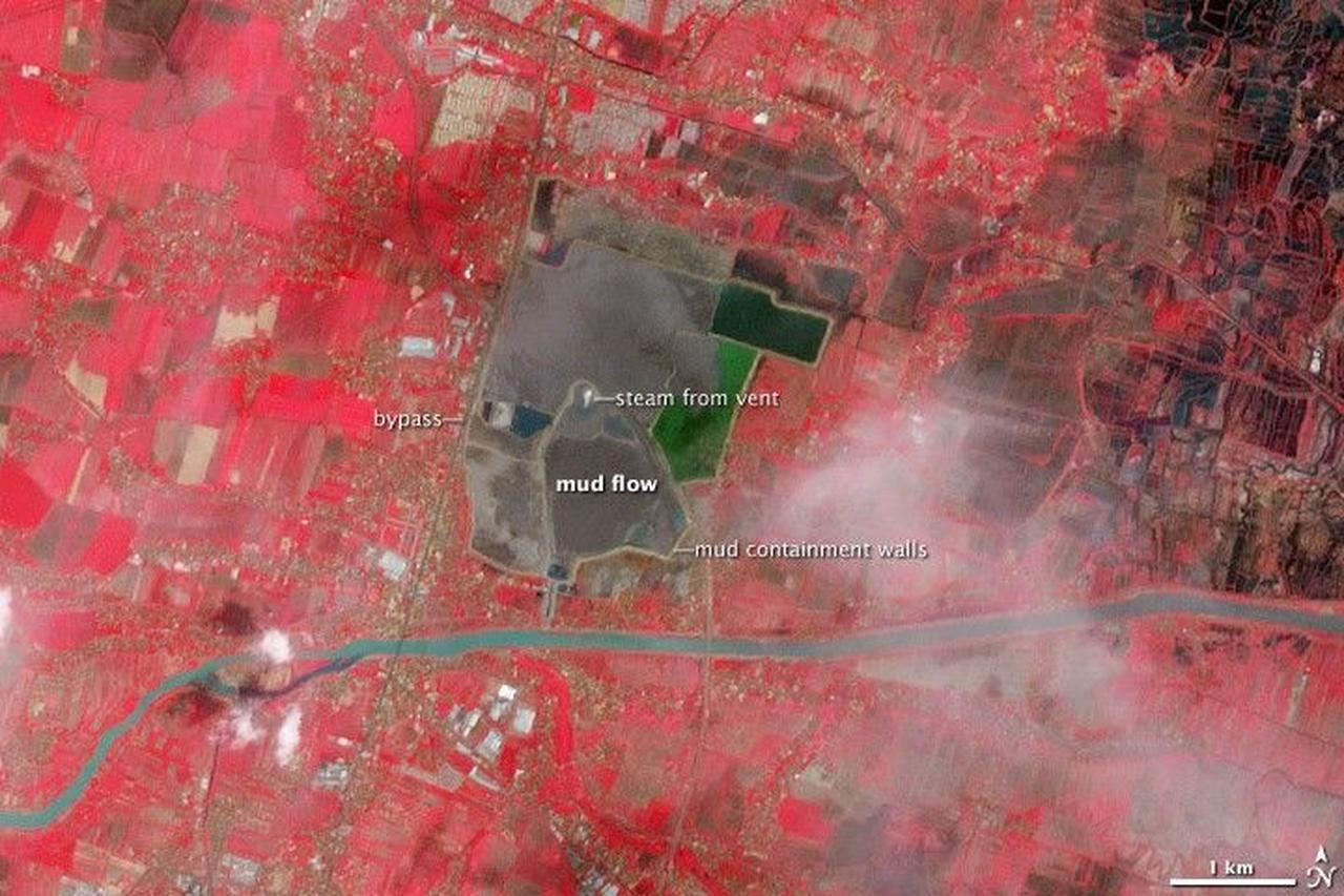 A satellite view of the Sidoarjo mud flow in Indonesia, showing the containment walls and steam venting from the center of the disaster zone. (Photo via NASA)