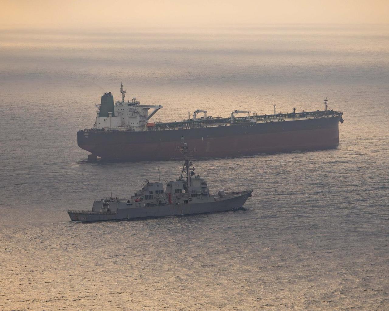 Guided-missile destroyer USS Rafael Peralta (DDG 115) patrols near a commercial tanker during US maritime operations in the Gulf, April 24, 2026. (Photo via X/@CENTCOM)