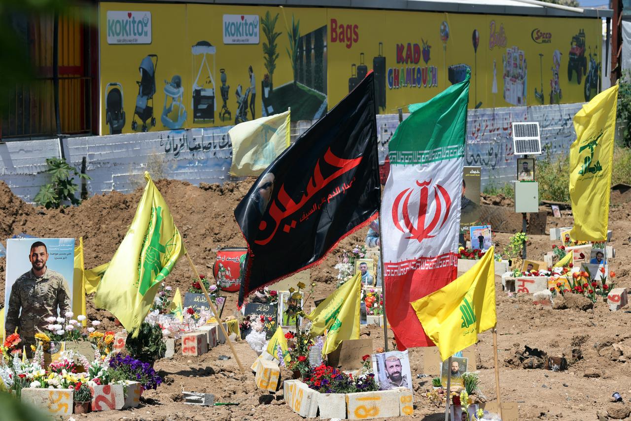 Hezbollah and Iranian flags flutter over the tombs of people killed recently at a temporary graveyard in the southern Lebanese coastal city of Tyre, April 30, 2026. (AFP Photo)