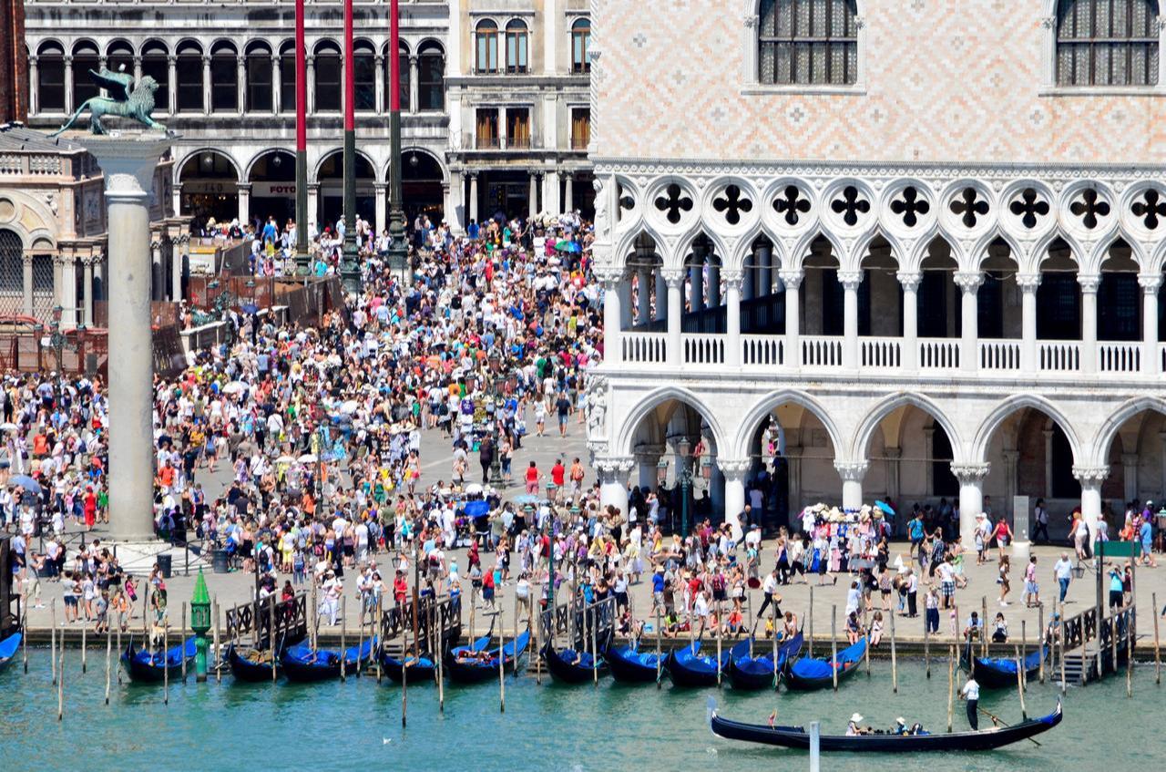 Tourists stroll through the crowded Piazza San Marco during the summer season in Venice, Italy. (Adobe Stock Photo)