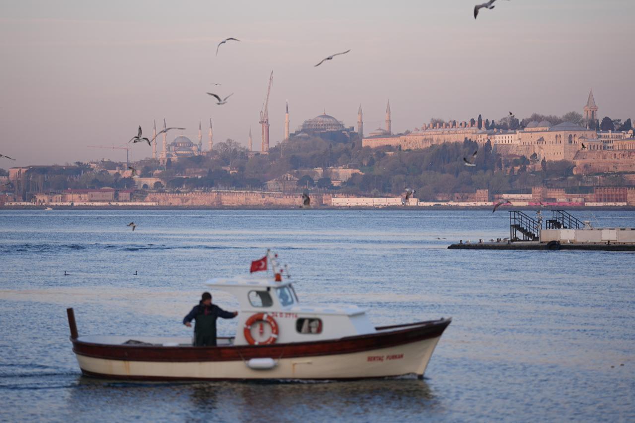A fisherman is seen on his boat during sunrise at the Bosphorus in Istanbul, Türkiye, on April 25, 2026. (AA Photo)