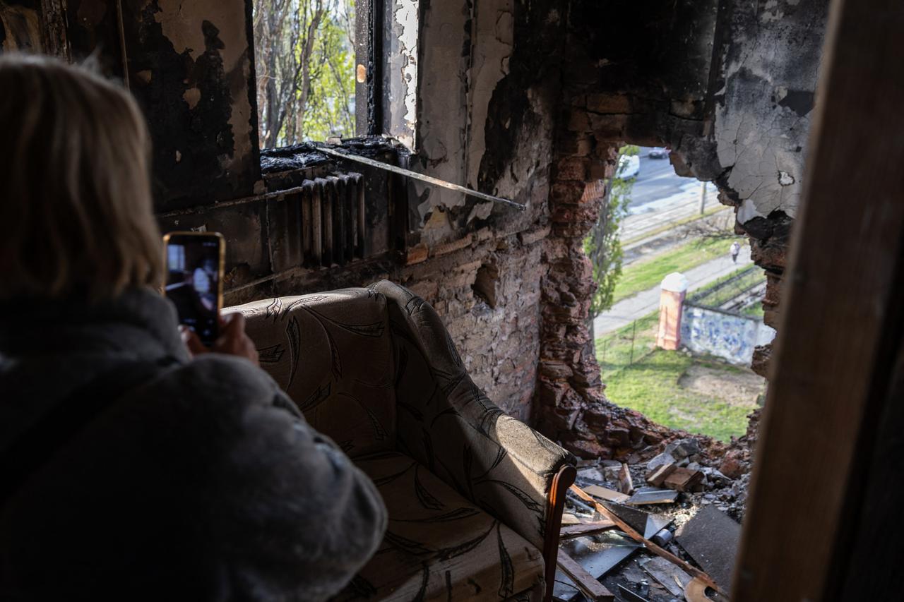 A woman photographs a damaged wall of a dormitory following an air attack in Odesa April 30, 2026. (AFP Photo)