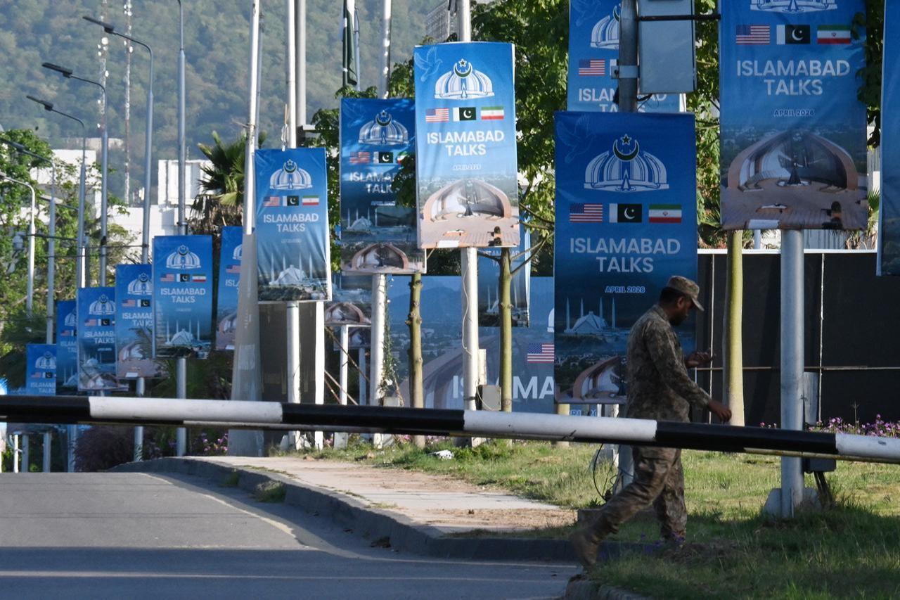 An army soldier walks past posters highlighting Pakistan's mediation of Iran–US peace talks near the Serena Hotel at the Red Zone area in Islamabad, April 22, 2026. (AFP Photo)