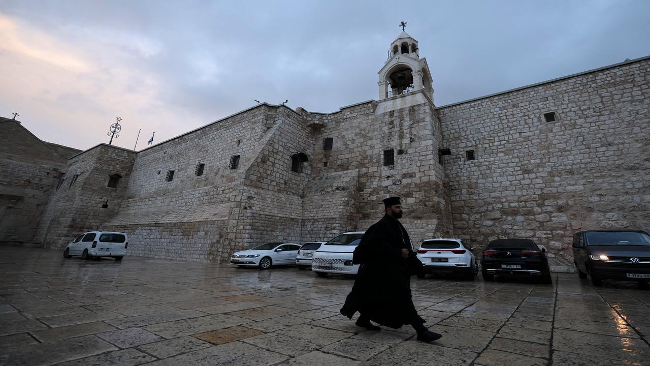 A priest walks in the empty square in front of the Church of the Nativity in the city of Bethlehem in the occupied West Bank, December 23, 2023. (AFP Photo)