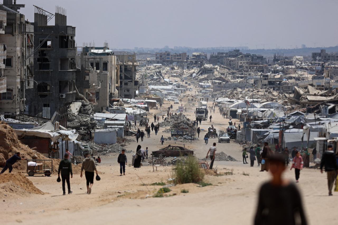 Displaced Palestinians make their way along a street with destroyed buildings at Jabalia in the northern Gaza Strip, May 6, 2026. (AFP Photo)