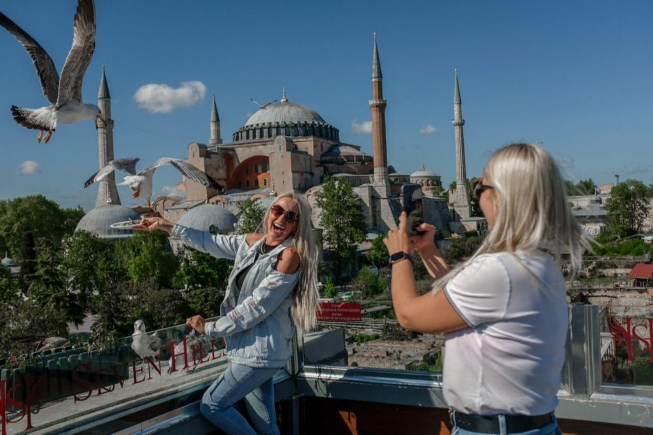 German tourists pose for photos and feed seagulls in front of Hagia Sophia in Istanbul, Türkiye. (Photo via Mediterranean Observer)