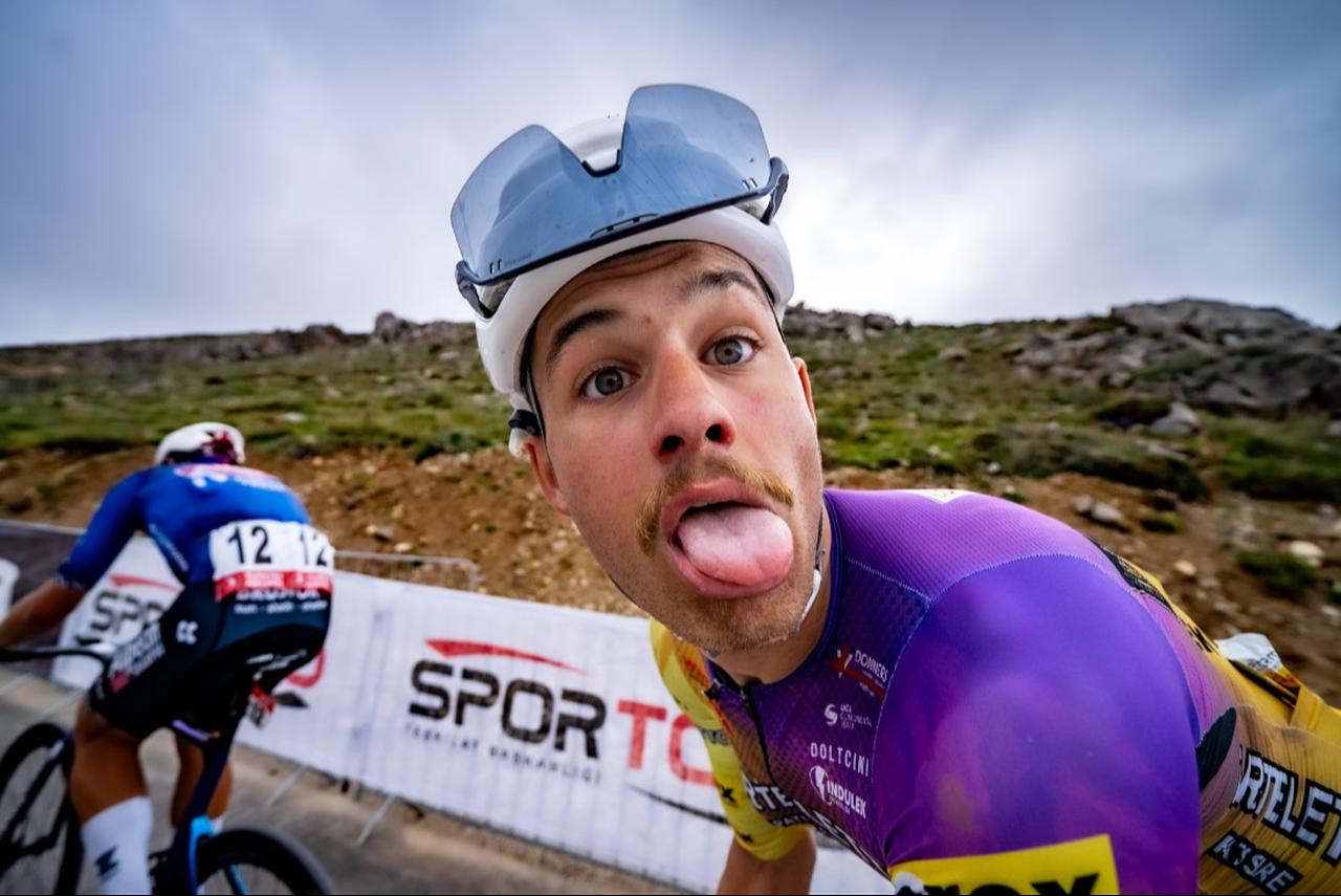 A rider playfully reacts to the camera during a climb, capturing a light moment amid the intensity of the race, April 2026. (Photo via Tour of Türkiye)