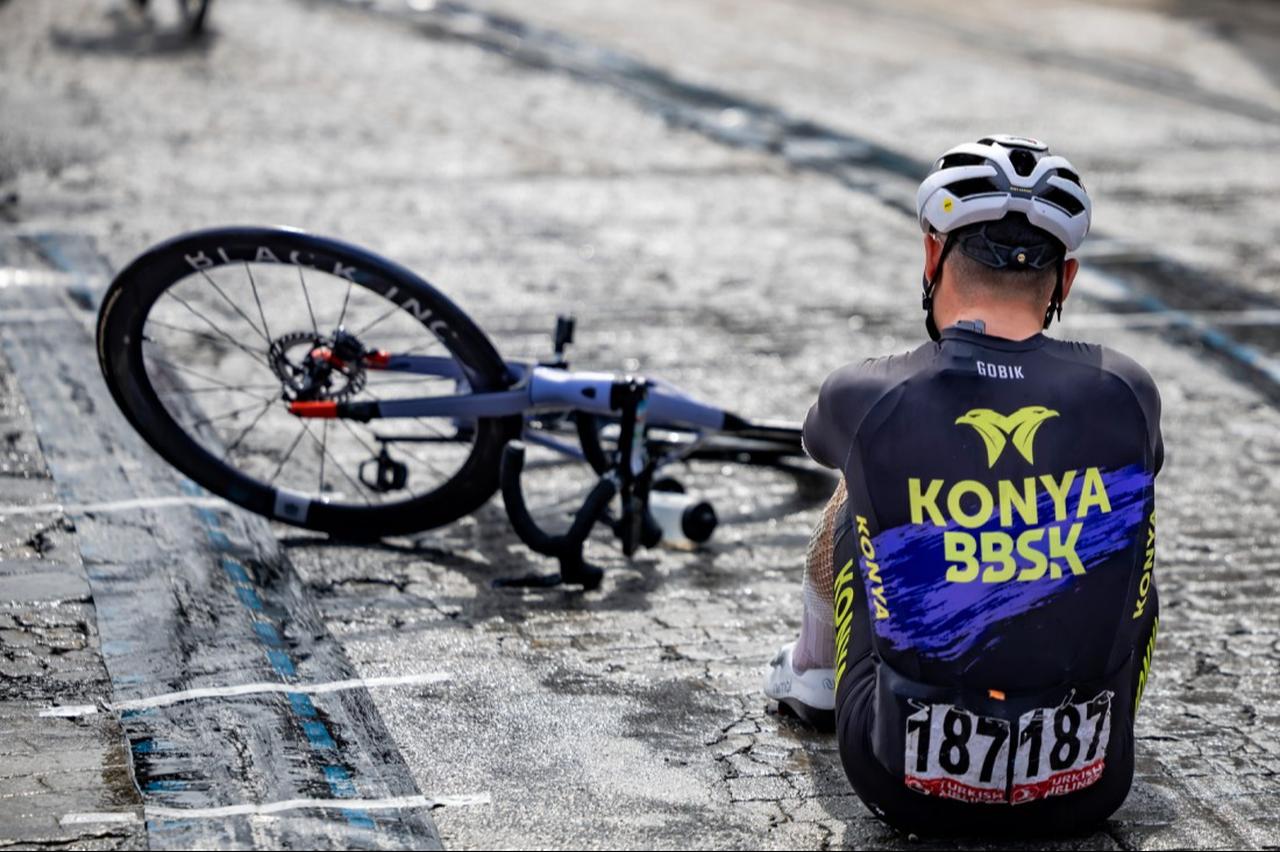 A cyclist sits on the roadside after a crash, highlighting the physical toll of the Presidential Cycling Tour of Türkiye, April 2026. (Photo via Tour of Türkiye)