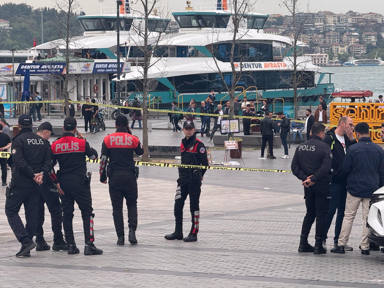 Police officers secure the area with cordon tape near the Besiktas ferry pier in Istanbul after a knife attack and subsequent police intervention left four people injured, including the suspect. (AA Photo)