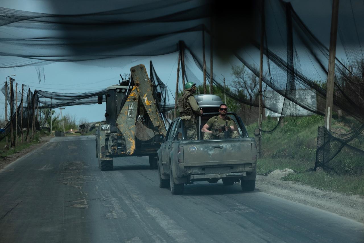 Photo shows Ukrainian servicemen of the Black Raven battalion ride in vehicles along a road covered with a net to protect vehicles from drone attacks at an undisclosed location, on May 7, 2026.  (The 93rd Kholodnyi Yar Separate Mechanized Brigade Handout / AFP Photo)