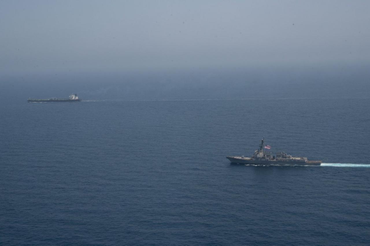 A US Navy guided-missile destroyer escorts a merchant vessel in the Arabian Sea, April 25, 2026. (Photo via X/CENTCOM)